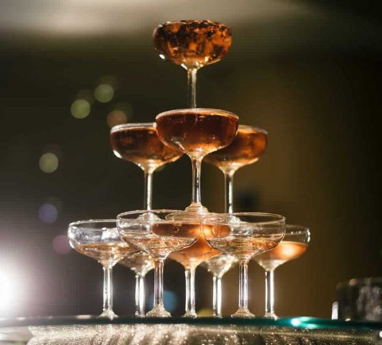 Champagne glasses stacked in a pyramid for celebration.